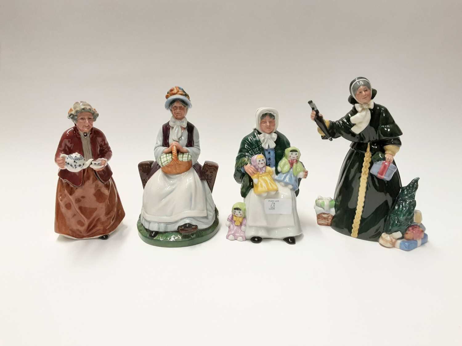 Lot 68 - Four Royal Doulton figures - Christmas Parcels HN2851, Rest Awhile HN2728, Teatime HN2255 and The Rag Doll Seller HN2944