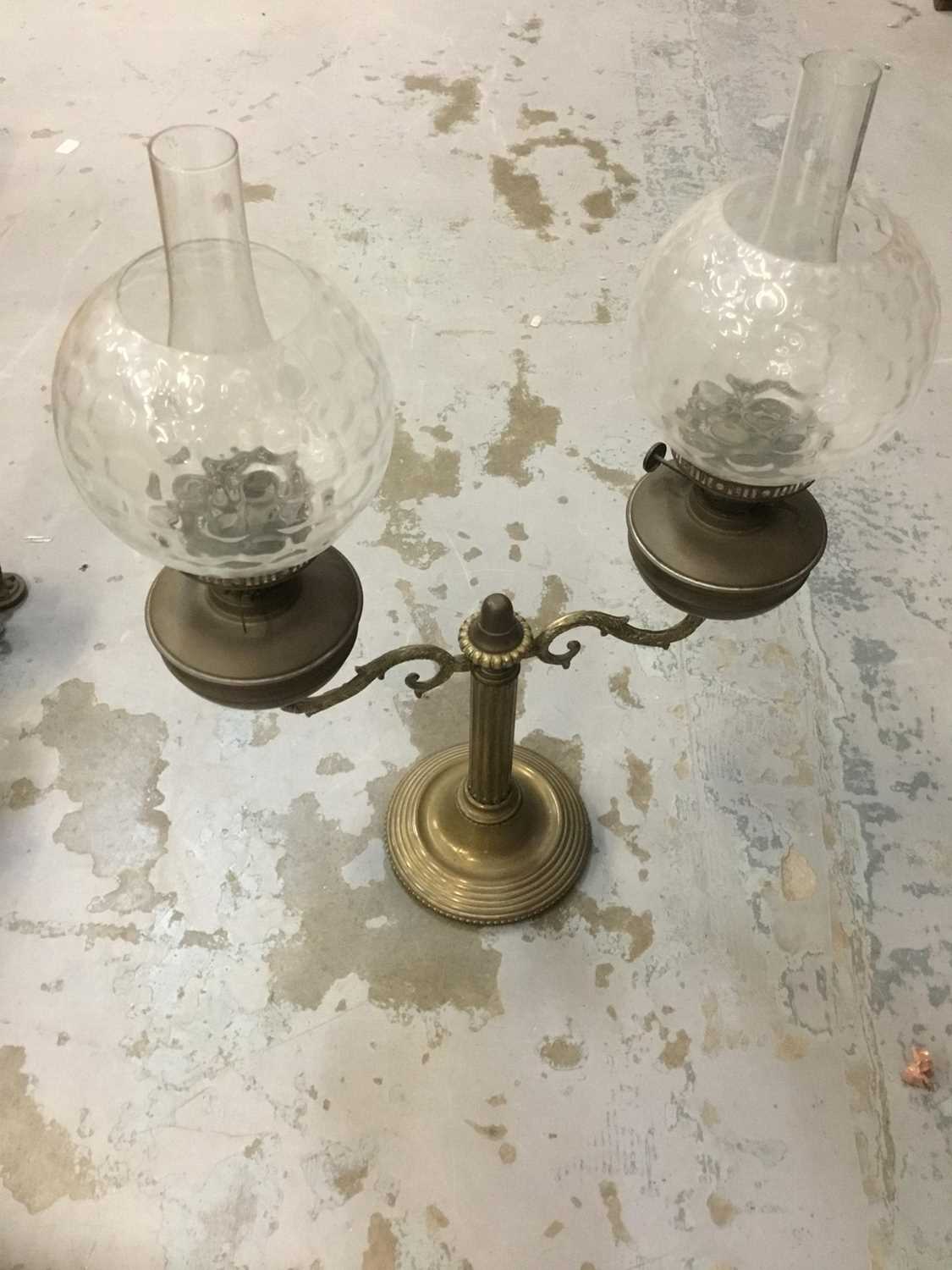 Lot 386 - Antique brass oil lamp with twin shades.