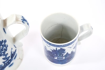Lot 260 - Lowestoft cylindrical mug, with a spreading foot and scrolled handle, boldly painted in blue with flowers and leaves, a spring and an insect to reverse, a diaper and half floret border below the in...
