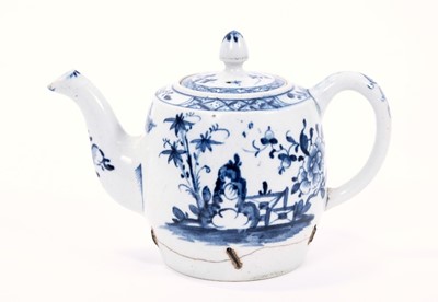 Lot 9 - Lowestoft teapot and cover, of barrel shaped with an acorn finial, painted in blue with outsized flowers and rockwork flanking a zig-zag fence, painter's number 8 inside the footrim, 11.5cm high