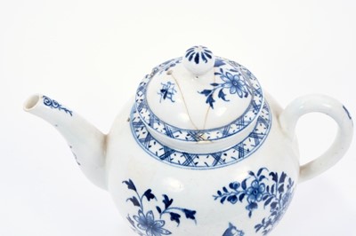 Lot 13 - Lowestoft teapot, of globular form with a curved spout and button finial, painted in blue with flowers and rockwork within a diaper border, 13cm high
