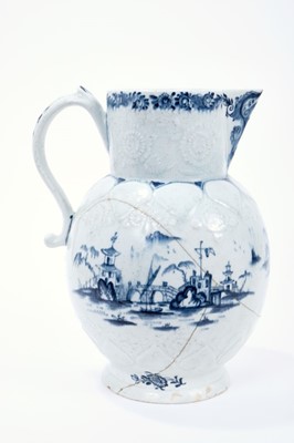 Lot 15 - Lowestoft jug, of large size, the neck moulded with flowers and leaves, the shoulder with lappets and flowers, painted in blue with a fisherman within an elaborate Chinese river scene, painter's nu...