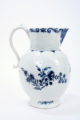 Lot 16 - Lowestoft jug, of large size, the neck moulded with flowers and leaves, lappets and florets around the shoulder and foot, painted in blue with flowering plants, painter's number 5 inside footrim, 2...