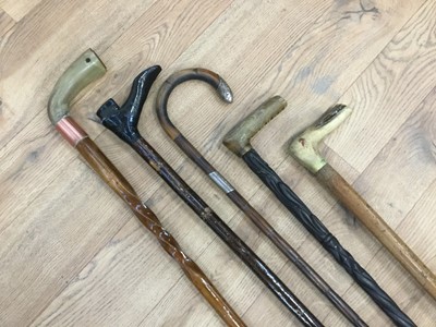 Lot 478 - Silver mounted walking stick, together with three walking sticks with horn grips and another modelled as a boot (5)