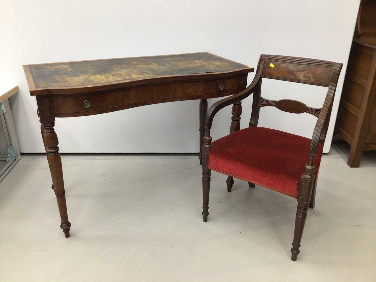 Lot 20 - Victorian figured mahogany serpentine front writing table, together with a Regency mahogany carver chair