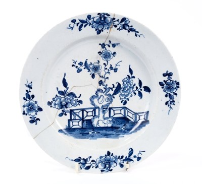 Lot 25 - Lowestoft plate, painted in blue with a flowering plant and rockwork within a fenced enclosure, four floral sprays in the border, 22.8cm diameter