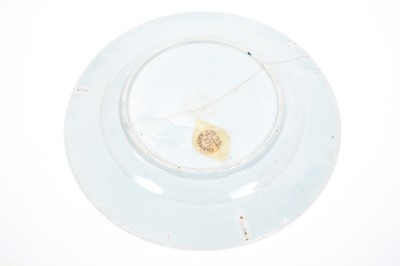 Lot 28 - Lowestoft plate, painted in blue with a Chinese lady by a zig-zag fence and a large vase of flowers, with a diaper and half-flowerhead border, 22.3cm diameter