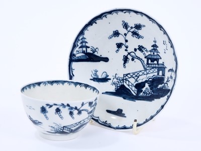 Lot 30 - Lowestoft tea bowl and saucer, painted in blue with Chinese river landscapes and a berry border, saucer 12.2cm diameter