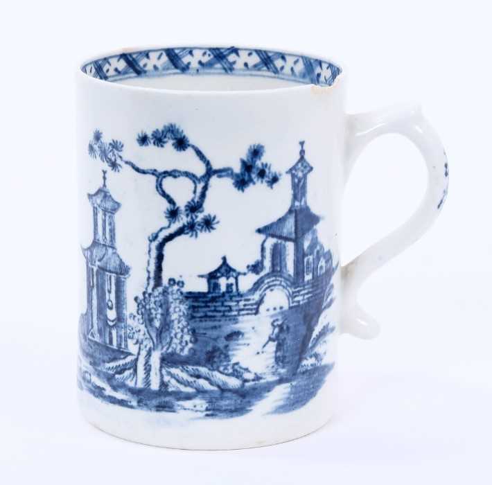 Lot 31 - Lowestoft mug, of small cylindrical form with a scrolled handle, printed in blue with a Chinese river landscape, a diaper border below the interior rim, 8.8cm high