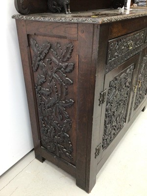 Lot 69 - Impressive 19th century Arts and Crafts carved oak Chiffonier, with arched gallery and shelf back raised on dragon supports, having two drawers and cupboards below on styles, allover relief carved...