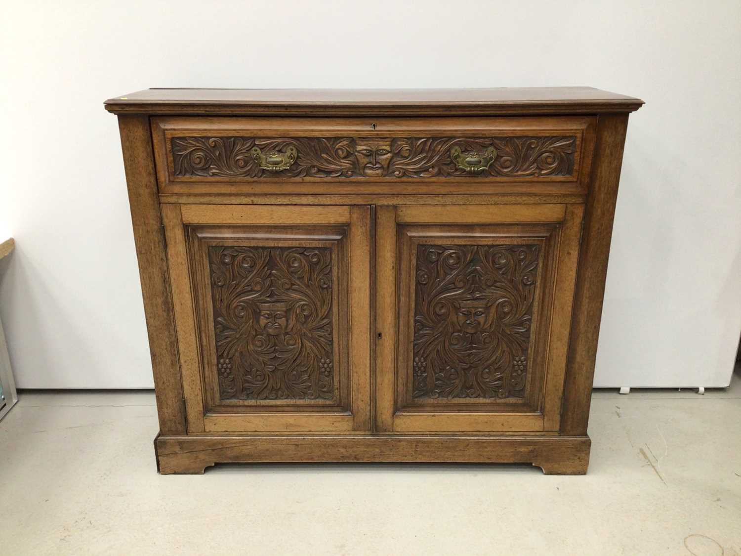 Lot 73 - Late Victorian carved walnut cupboard, with frieze drawer and pair of panelled doors belowm carved with mask and scroll ornament, 116 x 36cm deep x 98cm high