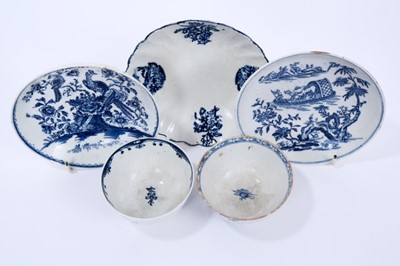 Lot 46 - Lowestoft tea bowls and saucers, including a tea bowl painted in blue with trailing flowers, another printed with flowering plants within a fenced enclosure,  a fluted saucer printed with panels of...