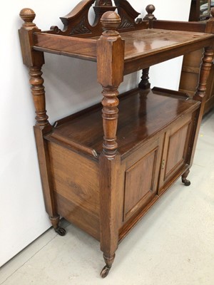 Lot 129 - Late Victorian carved walnut buffet with carved pediment to the back, turned supports and cupboard below enclosed by two panelled doors on turned legs with castors, 90cm wide x 113cm high x 42cm de...