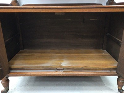Lot 129 - Late Victorian carved walnut buffet with carved pediment to the back, turned supports and cupboard below enclosed by two panelled doors on turned legs with castors, 90cm wide x 113cm high x 42cm de...