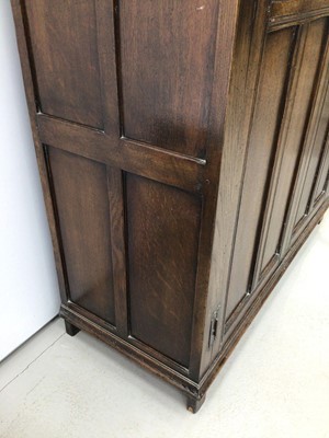 Lot 140 - Oak double wardrobe enclosed by two carved and panelled doors, 118cm wide, 48cm deep, 178cm high