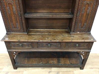 Lot 180 - Antique heavily carved oak two height dresser with open shelves and two carved cupboards above, three drawers and pot board below, 153cm wide, 39cm deep, 198cm high