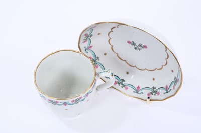 Lot 60 - Lowestoft coffee cup and saucer, of faceted form with a scrolled handle, the centre in pink and green with with a flower sprig within a gilded band, a 'Bungay' border enclosing a band of gilt stars...