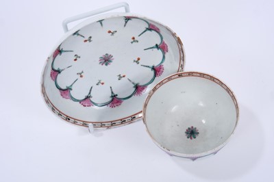 Lot 65 - Lowestoft tea bowl and saucer, enamelled with a wheel-like design in green and pink, within a red and black ermine border, 11.9cm diameter
