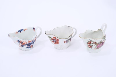 Lot 66 - Three Lowestoft cream jugs, the first of Low Chelsea ewer form, painted in 'Tulip Painter' style, 10.2cm wide, the second of the same form a painted in underglaze blue and red with floral sprays pi...