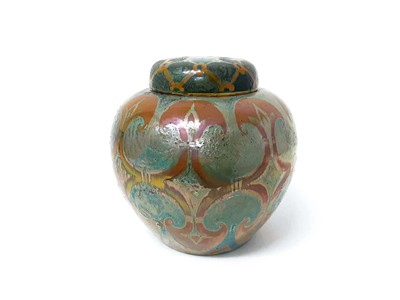 Lot 76 - Pilkington's Royal Lancastrian lustre jar, decorated by William S Mycock with a repeating motif in orange on a bluish green ground, marks to base, 21.5cm height including cover