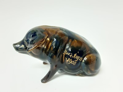 Lot 80 - Ewenny pottery model of a pig, with coin slot at the top, decorated with a mottled blue and brown glaze, with partly legible gilt inscription reading 'Born Aug 12 - 1908', 16.5cm length