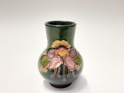 Lot 215 - Moorcroft pottery vase with floral decoration on blue and green ground, impressed marks to base, 11cm high