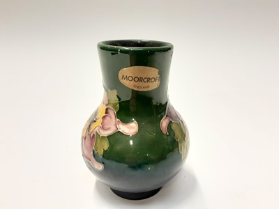 Lot 215 - Moorcroft pottery vase with floral decoration on blue and green ground, impressed marks to base, 11cm high