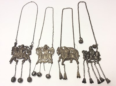 Lot 590 - Four Old Chinese white metal necklaces with embossed plaques depicting a figure on a dragon/horse, with bells on chain