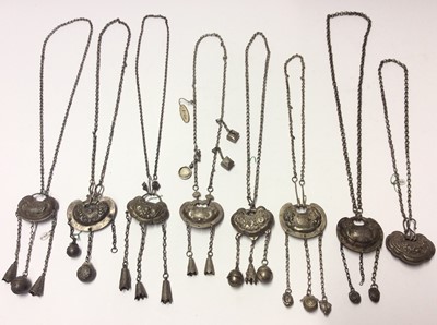 Lot 592 - Group eight old Chinese white metal necklaces with embossed panels depicting flowers, leaves and Chinese characters, with bells suspended on chains
