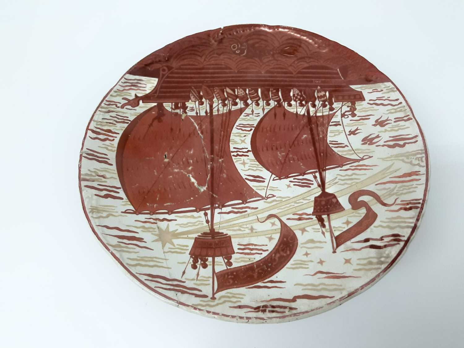 Lot 84 - William de Morgan tazza, c.1890, decorated in red lustre with a galleon by Charles Passenger, signed 'W.D.M Fulham' to base, with CP monogram, 10.5cm height x 23.5cm diameter