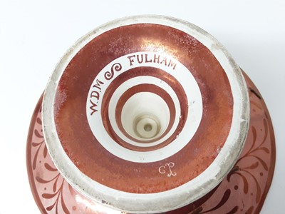 Lot 84 - William de Morgan tazza, c.1890, decorated in red lustre with a galleon by Charles Passenger, signed 'W.D.M Fulham' to base, with CP monogram, 10.5cm height x 23.5cm diameter