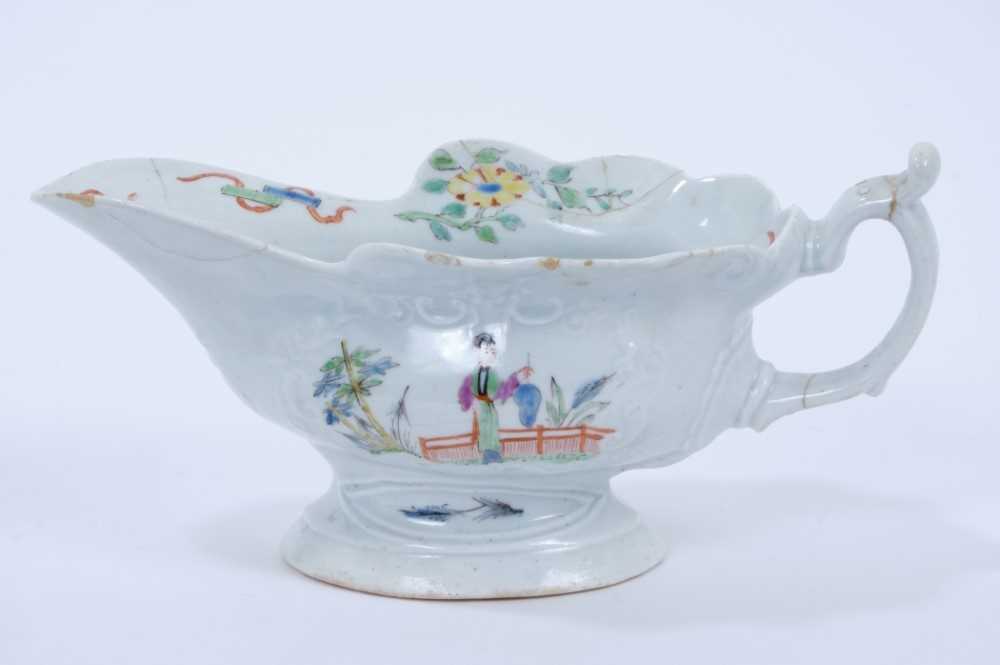 Lot 87 - Worcester silver shaped polychrome sauceboat, c.1755, the body moulded with two cartouches enamelled with chinoiserie scenes, the interior with flowers and precious objects, 19cm length