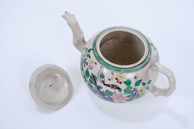 Lot 95 - Staffordshire salt-glazed teapot, c.1750, brightly enamelled on both sides with a tropical bird perched on rockwork, the cover with alternating patterned panels, with crabstock handle, spout and kn...