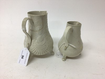 Lot 96 - Two Staffordshire white salt-glazed jugs, c.1750, both with relief moulded decoration and raised on three feet, 10.5cm and 13cm high