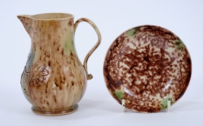 Lot 97 - Mid 18th century Whieldon type pottery jug and dish, the jug with relief-moulded floral sprigs below the spout and 11.4cm height, the dish 10.2cm diameter (2)