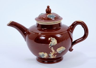 Lot 99 - Staffordshire lead-glazed pottery teapot, c.1750, the reddish brown body decorated with sprigs in yellow, green, blue and cream, with cream borders, 10.5cm height