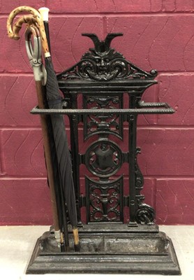 Lot 1429 - Victorian cast iron stick stand, with a shooting stick and umbrellas