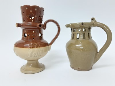 Lot 112 - Two salt glazed stoneware puzzle jugs, one in Doulton style and the other plain, both unmarked, 21.5cm and 18.5cm high