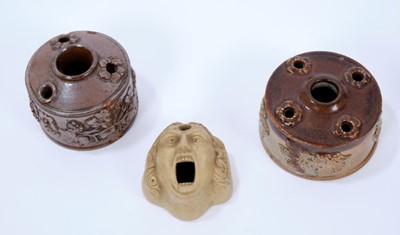 Lot 113 - Three 19th century stoneware inkwells, the first of mask form, 6.5cm long, and the other two salt glazed, of circular form with sprigged decoration, 7.25cm and 8.25cm diameter