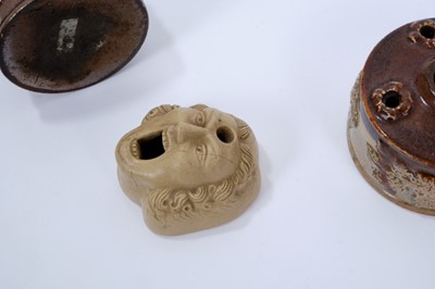Lot 113 - Three 19th century stoneware inkwells, the first of mask form, 6.5cm long, and the other two salt glazed, of circular form with sprigged decoration, 7.25cm and 8.25cm diameter