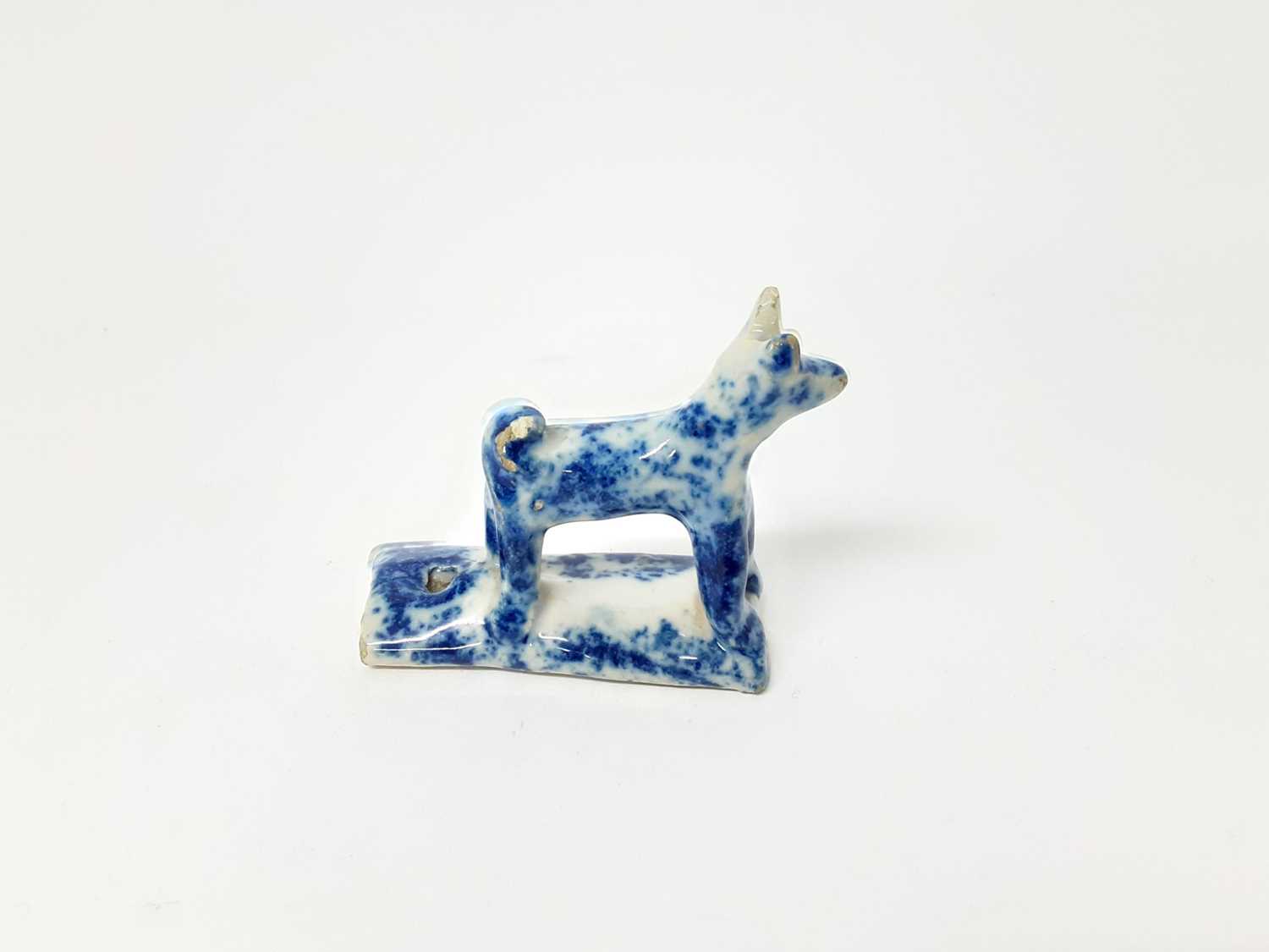 Lot 128 - 19th century English pottery whistle in the form of a dog, with blue sponge ware decoration, 5.25cm high