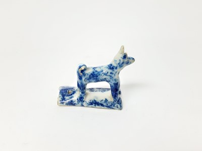 Lot 128 - 19th century English pottery whistle in the form of a dog, with blue sponge ware decoration, 5.25cm high
