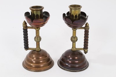 Lot 704 - Pair of late 19th century copper and brass candlesticks after a design by Christopher Dresser, with angular bobbin handles. patent registration numbers to each base 53791, 13.5cm high