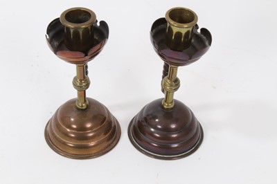 Lot 704 - Pair of late 19th century copper and brass candlesticks after a design by Christopher Dresser, with angular bobbin handles. patent registration numbers to each base 53791, 13.5cm high