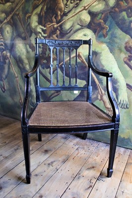 Lot 1501 - Regency ebonised open armchair, with relief carved tablet back and caned seat on patera headed square tapered legs