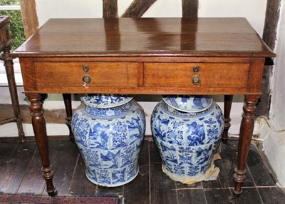 Lot 1507 - Victorian oak library table, the rectangular top with moulded edge over twin drawers and opposing dummy drawers, raised on turned legs and brass castors, 107cm x 59cm wide x 79cm high