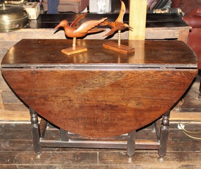 Lot 1511 - Early 18th century oak drop leaf dining table, with oval hinged top over end frieze drawer on turned and block understructure, 122cm x 149cm