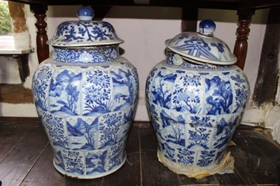 Lot 1529 - Two similar large Chinese Kangxi blue and white baluster vases and covers, each with associated finialled cover and decorated with segmented alternating foliate and landscape reserves, approximatel...