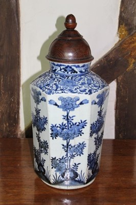 Lot 1531 - 17th/18th century Japanese baluster vase, with associated carved hardwood cover, the hexagonal vase decorated in blue and white with shrubs