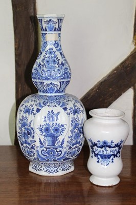 Lot 1533 - 18th century tin glazed drug jar, waisted baluster form with blue title, 19cm high, together with a 19th century Dutch blue and white ribbed baluster vase, 43cm high